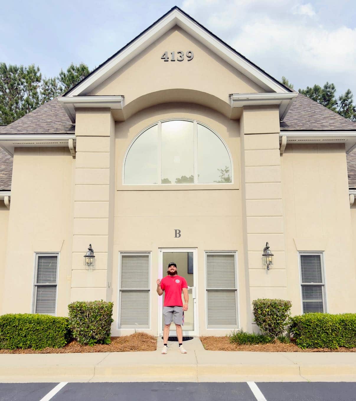All American Roofing - a man standing in front of a building